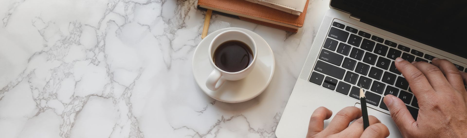 Portrait of a man working with a laptop and coffee beside him.