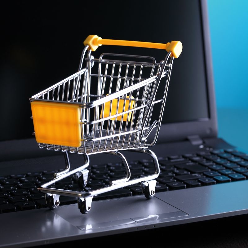 A shopping cart on top of a laptop